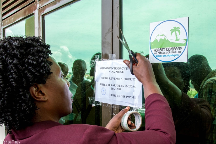 An official puts a notice of closure at the entrance of Forest Company yesterday. (Doreen Umutesi)