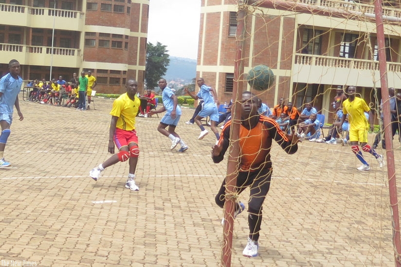 Police players (in blue) try to advance after concending against UR-CE (in yellow) at the UR-CE handball court. (S. Kalimba)