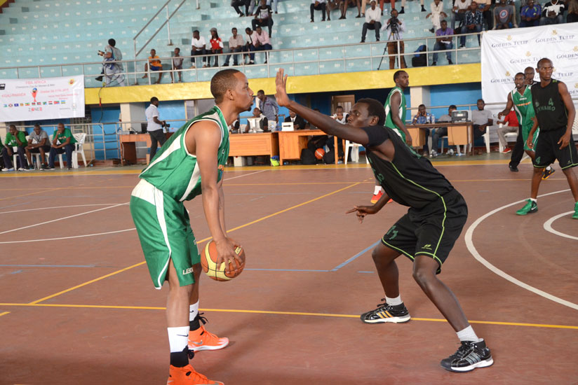 Lionel Hakizimana holding a ball blocked by Dynamo Players during the match against Burundi's Dynamo BBC yesterday. (Sam Ngendahimana)