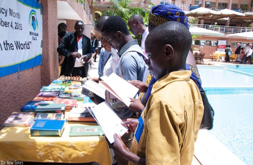 People read books at an exhibition stall on Tuesday. (Teddy Kamanzi)