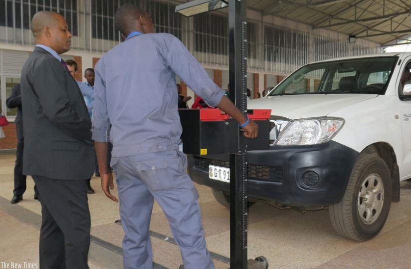 Kayihura (R) inspects a car at the car at the new workshop during a test exercise in Huye District as Jerome Gasana, the director general of WDA, looks on. (Emmanuel Ntirenganya)