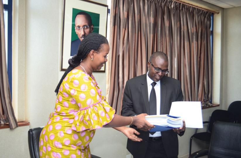 (L_R): Dr Solange Hakiba, the permanent secretary at the ministry of health handing over Mutuelle documents to Jonathan Gatera, the RSSB director general. (Theogene Nsengimana)