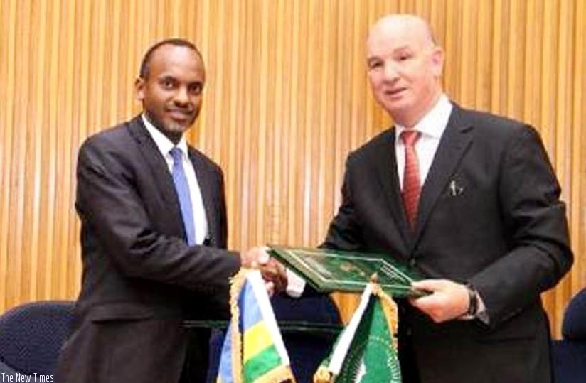Rwanda's Charge d' Affaires in Ethiopia, Phillip Karenzi (L), and Chergui exchange documents after the signing of the agreement in Addis Ababa, Ethiopia, last week. (Courtesy)