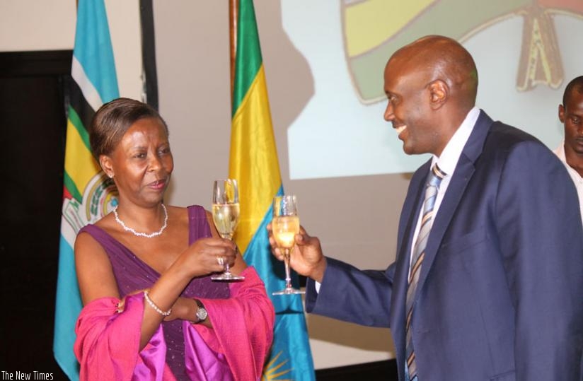 Minister Louise Mushikiwabo (L) shares a toast with Uganda's High Commissioner Richard Kabonero.
