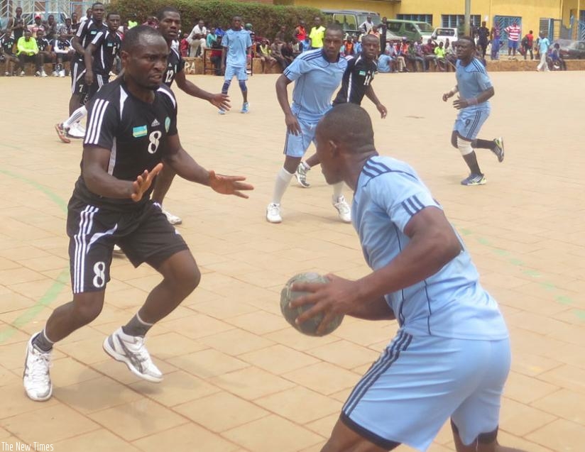 APR's Viateur Rwamanywa tries to stop Police's Jean Paul Muhawenayo during the last game of the handball league season on Saturday. (S. Kalimba)