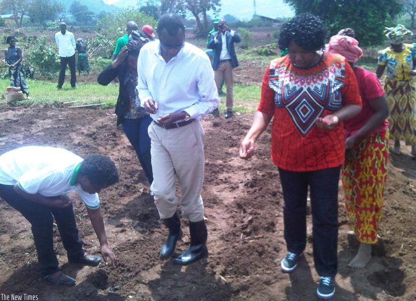 Minister Musafiri (C) and Mayor Mukasonga (R) plant maize to launch the first farming season for Nyarugenge in Kinyinya Sector on Tuesday. (Steven Muvunyi)