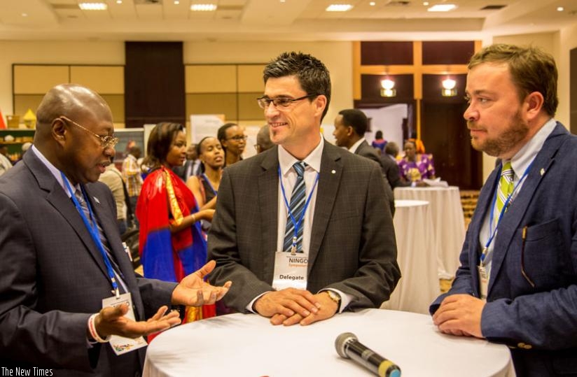 Manneh (L), Auger (C) and John Ames, the chief of party of Global Communities, chat during a break during the NINGO meeting in Kigali yesterday. (Doreen Umutesi)