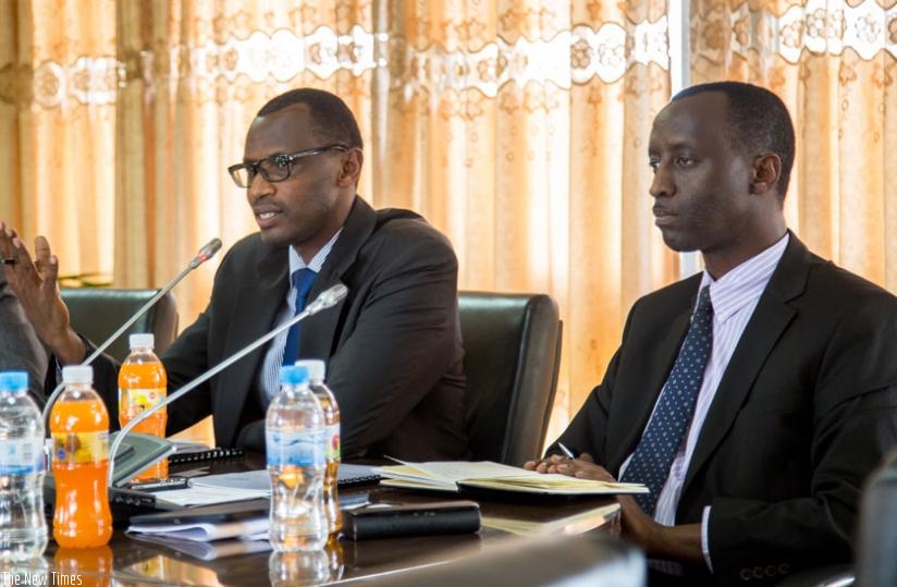 Education minister Papias Musafiri (L) explains to the media how student loan disbursement will work as Alex Kanyankole (R), the chief executive of Development Bank of Rwanda listens. (Doreen Umutesi)