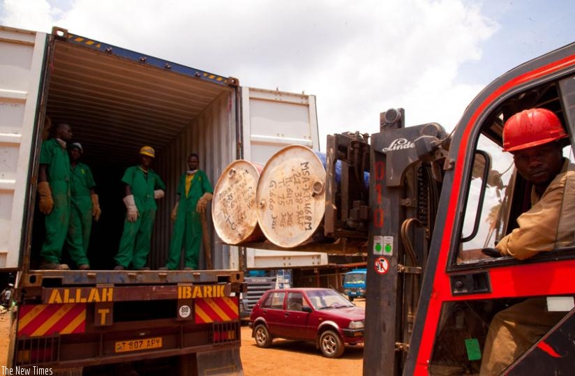 Workers at Mineral Supply Africa Company load containers of minerals on to trucks. (Timothy Kisambira)