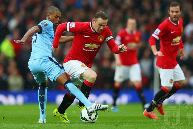 Man United captain Wayne Rooney tries to charge past Man City's Fernandinho last season. (Net photo)