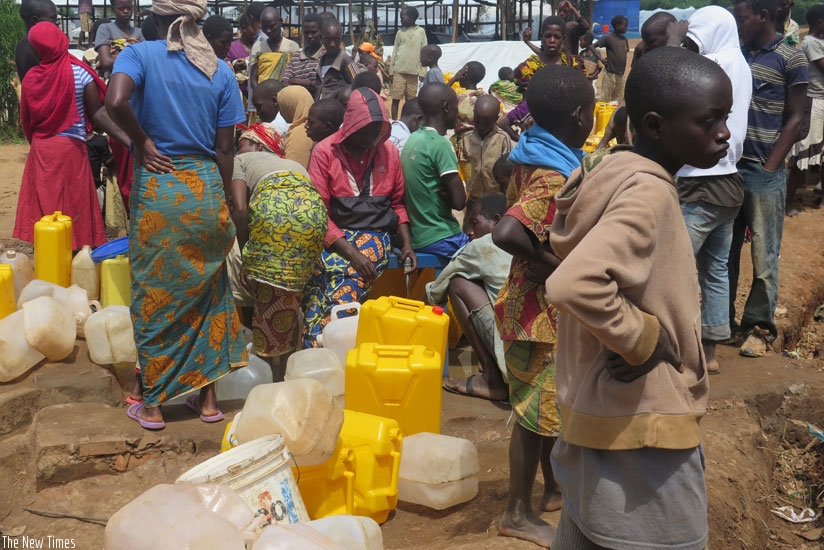 Burundian refugees waiting in a queue to fetch water in Mahama Camp. (Timothy Kisambira)