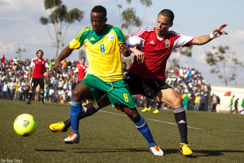 Amavubi captain Haruna Niyonzima (number 8) fights for the ball against Libya last year at the Kigali Regional Stadium in Nyamirambo. (File)
