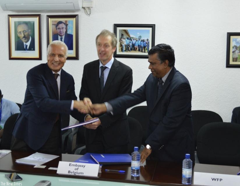 L-R: Saber Azam, UNHCR representative in Rwanda; Arnout Pauwels, the Belgium ambassador to Rwanda; and Jean Pierre de Margerie, WFP representative shake hands after announcing the donation. (Theogene Nsengimana)