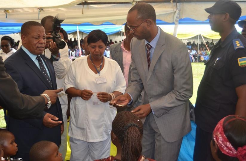Bosenibamwe (left), a nurse (middle) and Kamanzi (right) give medicine to children at the launch of the week-long national campaign. (Jean Fidele  Ndungutse)