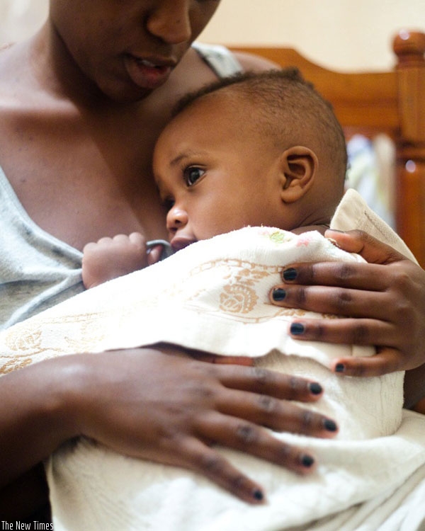 A mother carries her child. The maternity fund is expected to allow new mothers more time with their infants. (File)