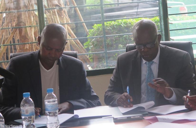 Katabarwa (L) and Nzagahimana sign  the  Memorandum of Understanding at Rwanda Institute of Cooperatives, Entrepreneurship and Microfinance Office in Kabusunzu on Friday. (Frederic Byumvuhore)
