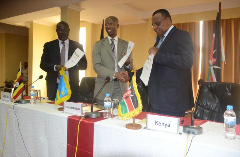 Rwanda's Internal Security Minister, Sheikh Musa Fazil Harerimana exchanges signed copies on exchange of criminal fugitives with Amb. John Mwengemi as Amb. James Baba, Uganda's Minister of State for Internal Affairs looks on. (Courtesy)
