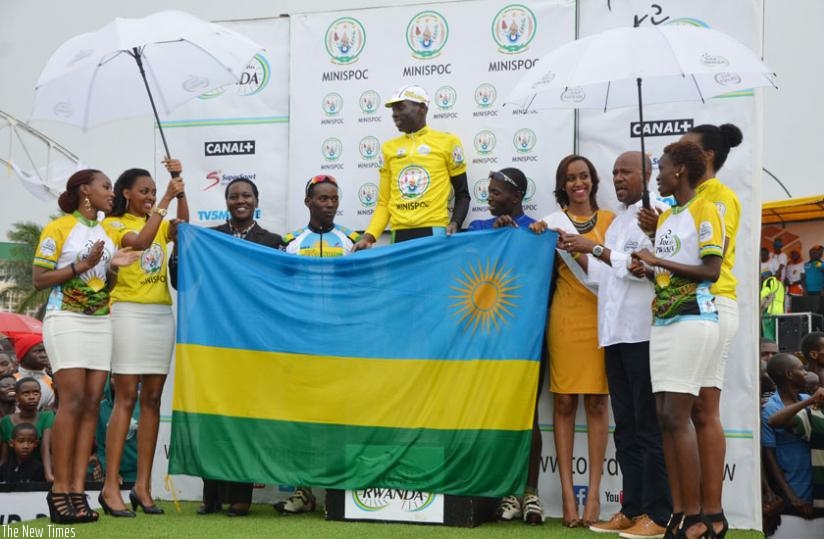 Jean Bosco Nsengimana (C) of Team Rwanda - Karisimbi, celebrates  after winning the 2015 Tour du Rwanda at Amahoro Stadium in Kigali yesterday. With him are the Minister for Sports and Culture, Julienne Uwacu  (3rd left), other Team Rwanda riders, officials and ushers. (Sam Ngendahimana)