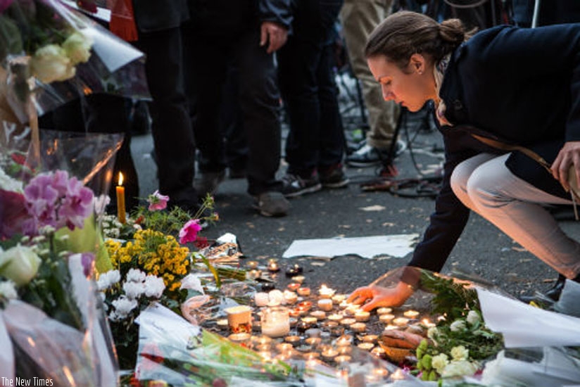 People place flowers and light candles in tribute for the victims of the Paris terror attacks. (Net photo)