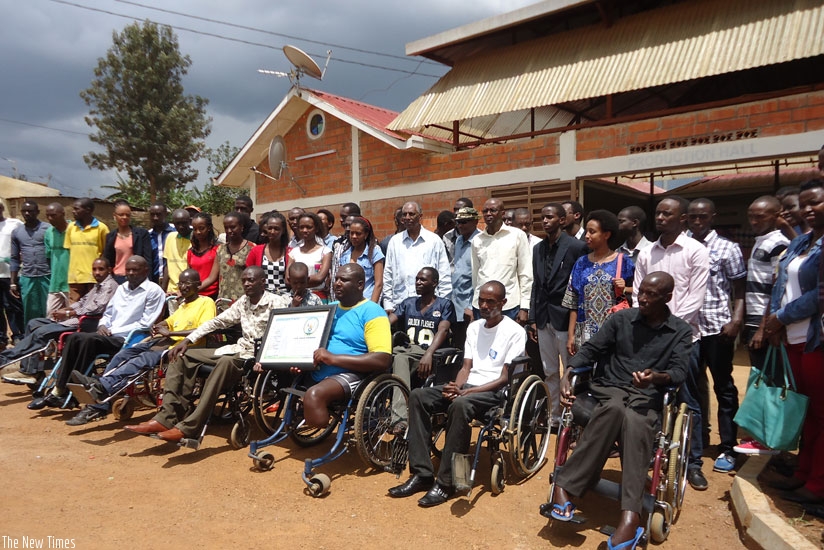 Ex-combatants (front row) pose for a group photo with Jean Sayinzoga and King David Academy students (back row) when the students visited the veterans in Nyarugunga village of Kanombe Sector recently. (John Mbaraga)
