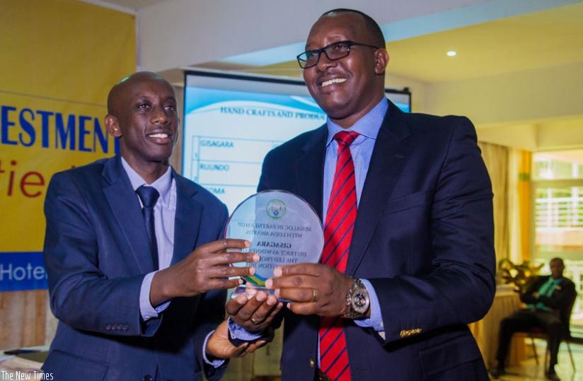 Kaboneka (L) hands over the winner's  award to Gisagara mayor Leandre Karekezi. Faustin Niyigena.