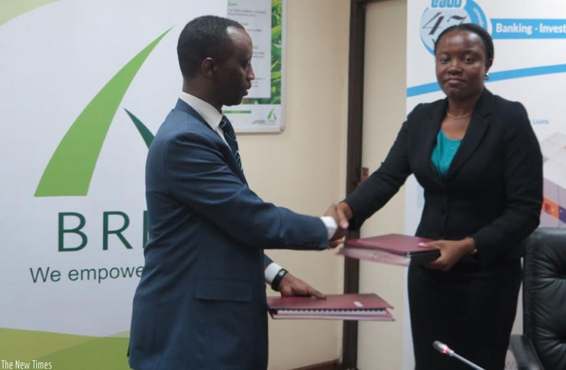 Kanyankole (L) and Yeda exchange documents after signing the deal. (Courtesy)