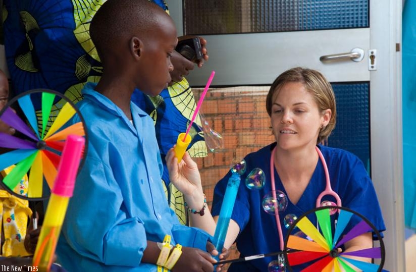 Carly Steeger, a ward nurse, talks  to a heart patient after a successful surgery at King Faisal Kigali during a past surgical activity for children. (File)