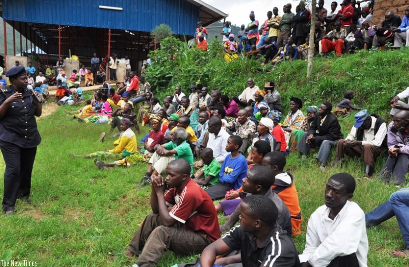 Gicumbi residents listen to an officer as she briefs them about the mobile Police station services. (Courtesy)