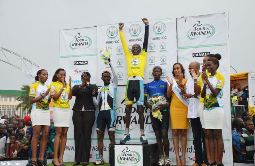 NEW HERO: JB Nsengimana enjoys his victory after winning the 2015 Tour du Rwanda as Areruya, to his right and Byukusenge, on the left, as well as Sports and Culture minister Julienne Uwacu (in black suit), Miss Rwanda Doriane Kundwa, FERWACY boss Aimable Bayingana (3rd R) and ushers, applaud on at the podium. (S. Ngendahimana)