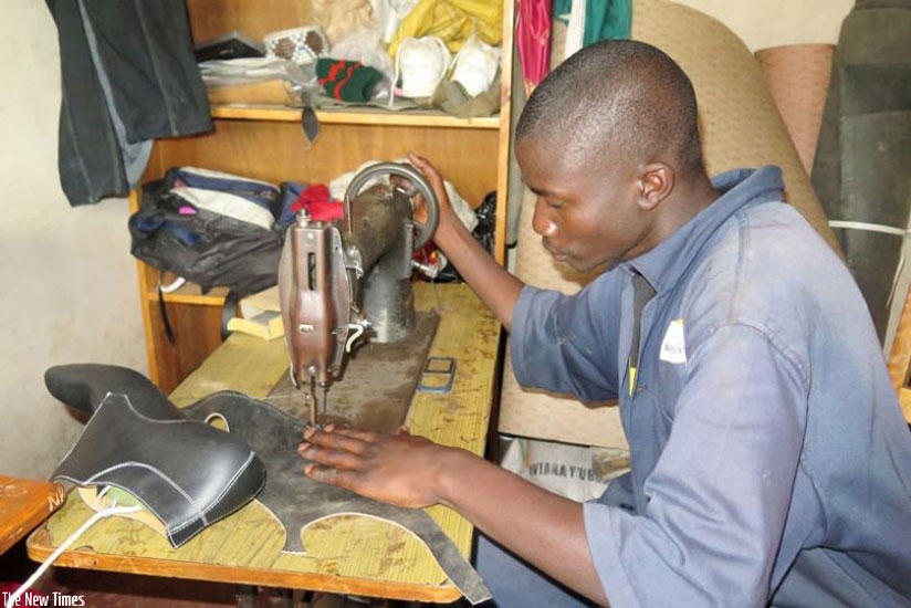 Alphonse-Karangwa of Twitezimbere Cooperative in Kibeho sector in Nyaruguru sews leather to make shoes early this year. Tax on second hand leather products has been raised to 100% imposed to support local industries. (File)