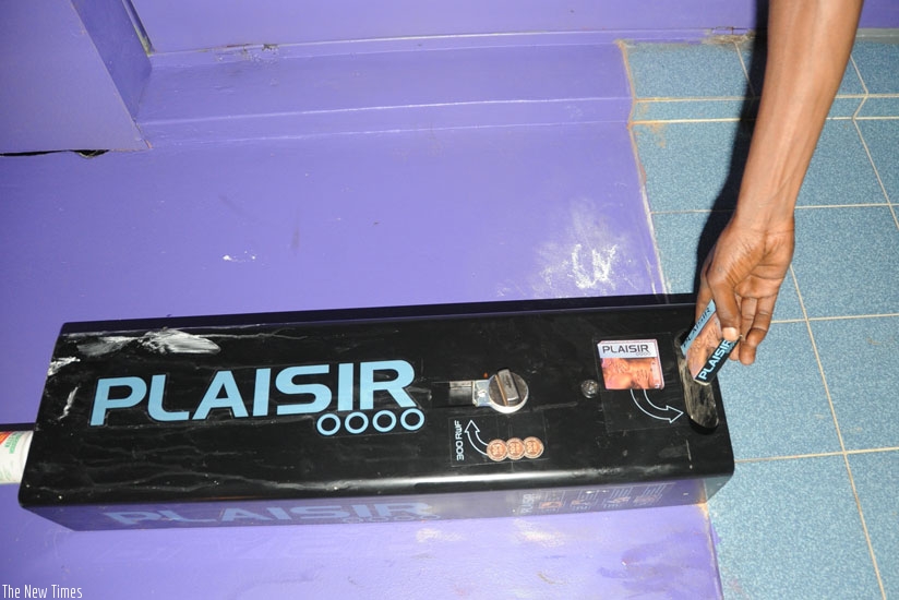 A customer pulls a condom from a dispenser. (File)