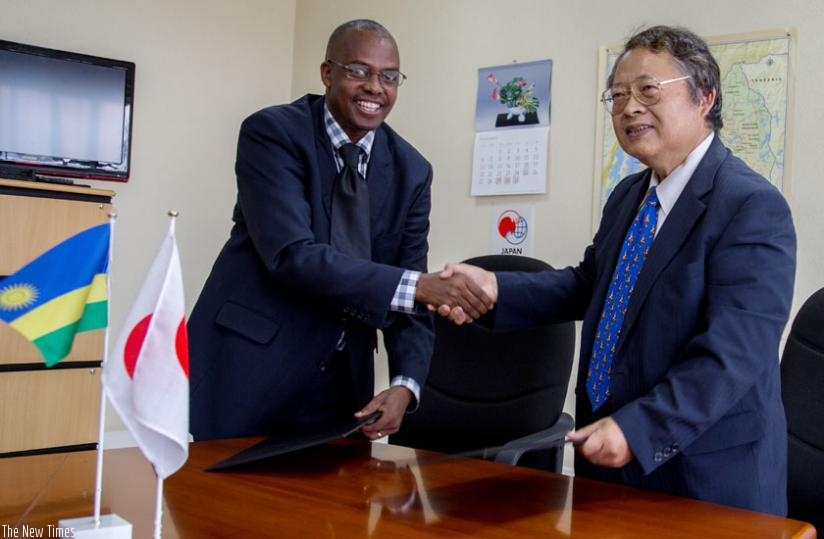 Munyurangabo (L)  and Sakamoto exchange a contract after the signing at the Embassy of Japan in Kigali yesterday. (Doreen Umutesi)