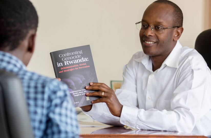 Dr Gasanabo holds his new book during the interview last week. (Timothy Kisambira)