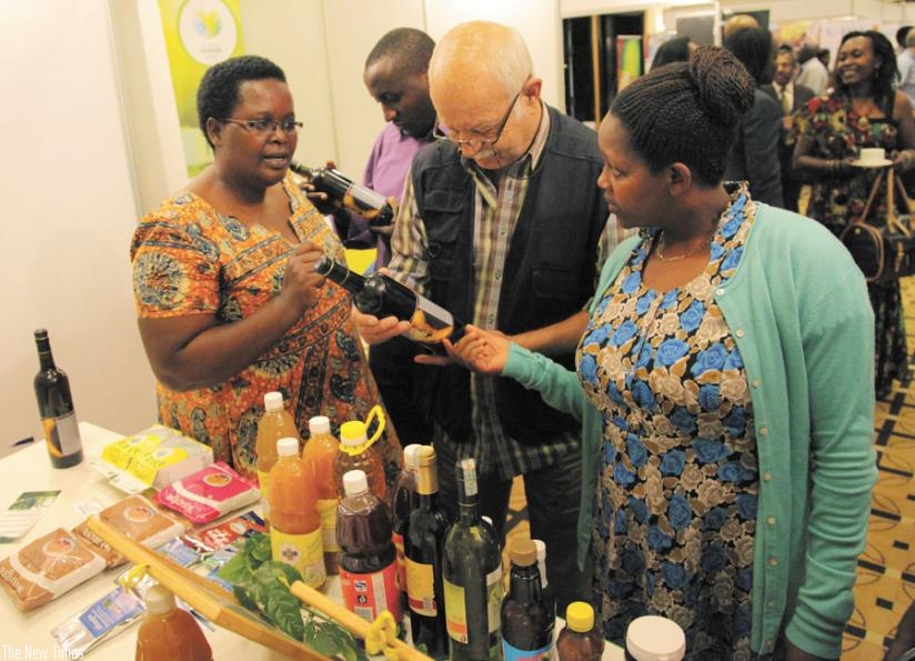 Christine Murebwayire (left) shows packaged banana wine to clients in a 2014 picture. SMEs like hers must make planning an essential component of their businesses. (File)