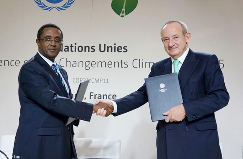 Minister Biruta shakes hands with De Boer after signing the Green Fund deal in Paris. (Courtesy)