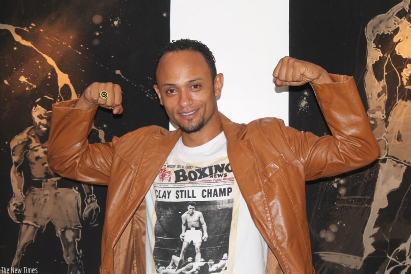 Muco Mu strikes a pose infront of some of his paintings at the Innovation Village . (All photos by Moses Opobo)