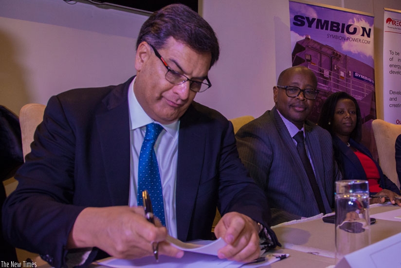 Hinks signs the deal witnessed by Musoni and other officials yesterday. (All photos by Faustin Niyigena)