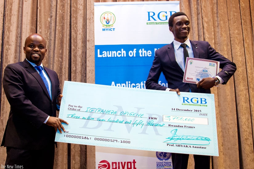 The Minister for Youth and ICT, Jean-Philbert Nsengimana, awards a dummy check to Origene Igiraneza, winner of a mobile application competition.