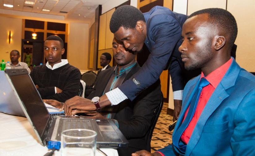 The winner of the mobile application competition, Igiraneza (2nd Right), compares notes with  the other contestants during the ceremony in Kigali, on Monday. (Faustin Niyigena)