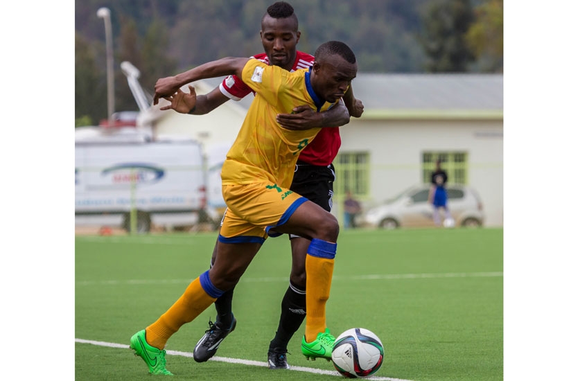 Amavubi captain Jacques Tuyisenge tries to get past a Libyan defender in a World Cup Qualifier last month.  (T. Kisambira)