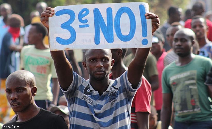 A protester holds a placard as they demonstrate against the ruling CNDD-FDD party's decision to allow Burundian President Pierre Nkurunziza to run for a third five-year term in office in May. (Net photo)