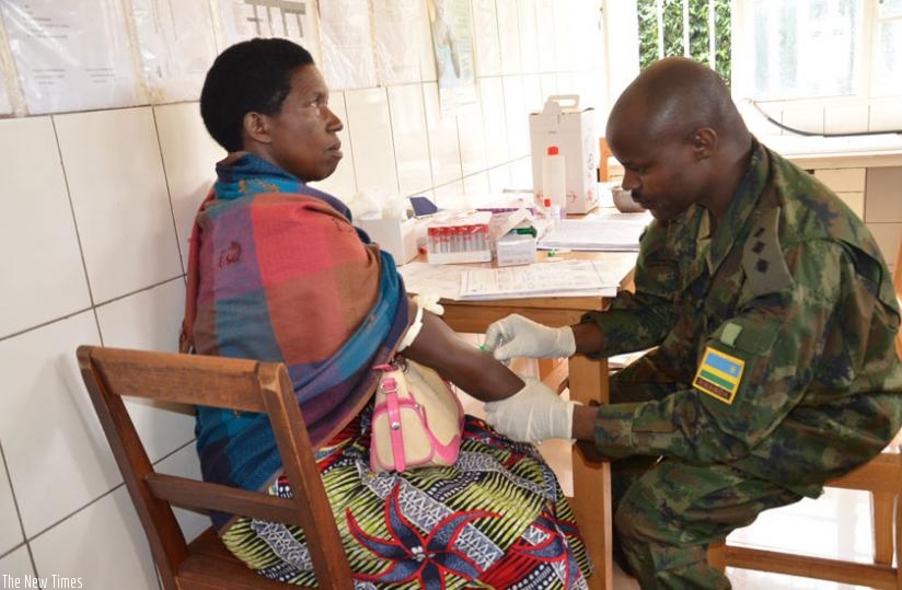 An army officer attends to a patient during the Army Week Medical Outreach in Kamonyi District on Monday. (Courtesy)