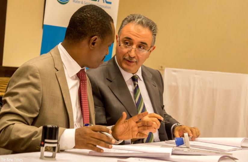 WASAC chief executive James Sano (L) chats with Nakiboglu Beyhan, chief executive of American firm Culligan International, at the signing of the contract in Kigali yesterday. (Doreen Umutesi)