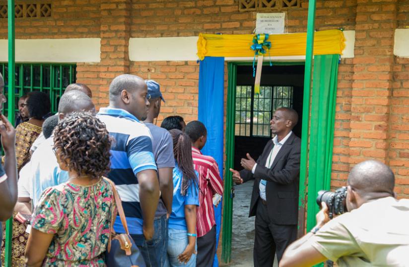 A polling assistant gives instructions to voters at Remera Catholic Primary School yesterday. (Doreen Umutesi)
