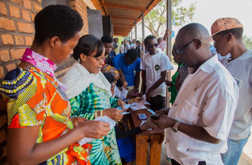 Citizens search for their voter cards at Ecole Sainte Famille polling centre in Kigali. (Faustin Niyigena)