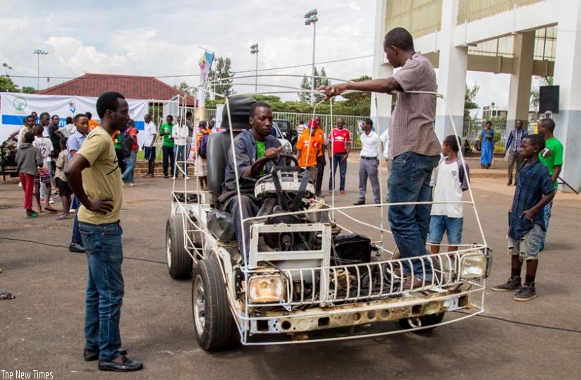 Eric Hakizimana, a teacher at EMVTC, a vocational school in Remera, showcases a prototype car that was assembled by his students. (Doreen Umutesi)