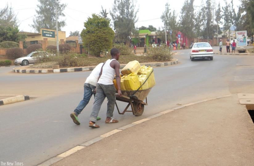Young men ferry jerrycans of water in Gikondo, a city suburb. (File)