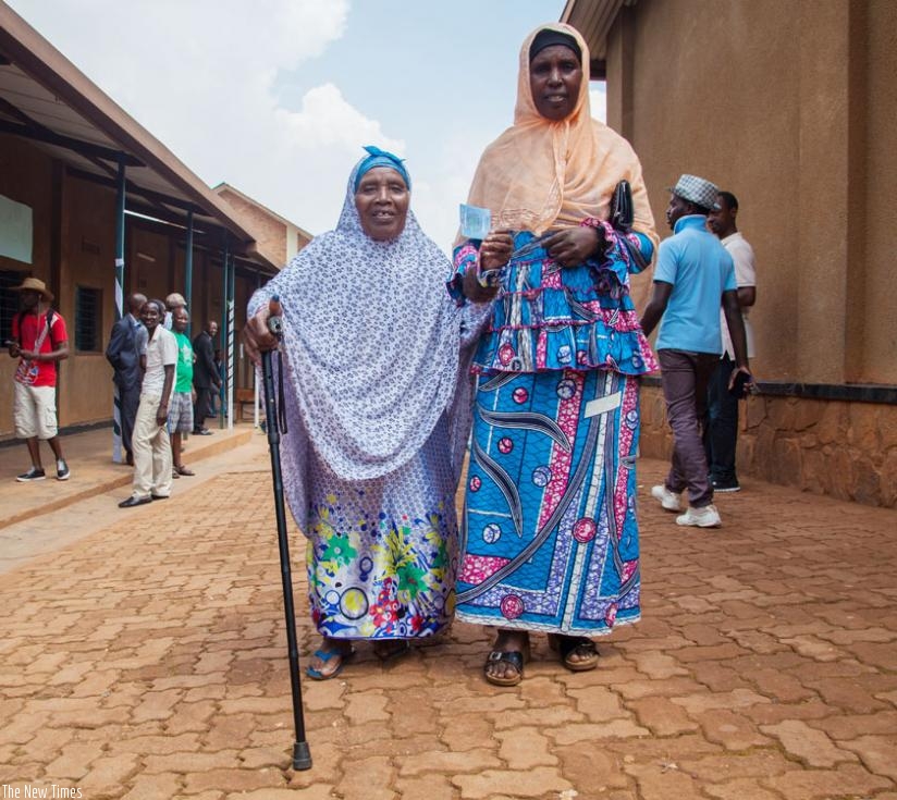 Zura Mukaruhara, 85, (L), shows her card after voting in the referendum at Ntwari polling centre in Nyamirambo Sector, on Friday. (Faustin Niyigena)