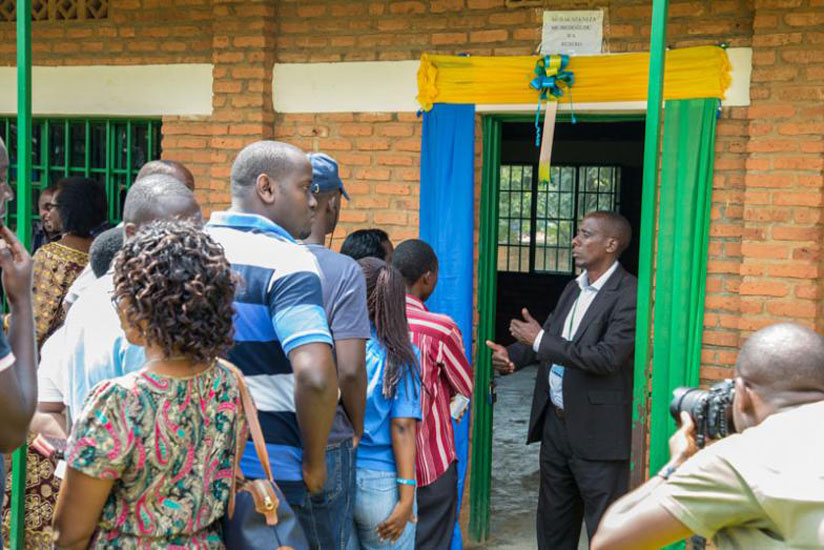 A polling assistant gives instructions to voters at Remera Catholic Primary School on Friday. (Doreen Umutesi)