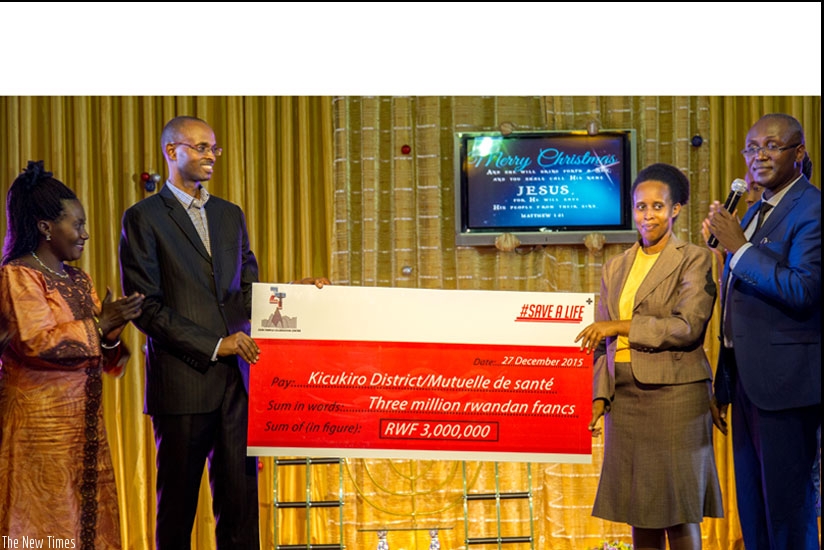 James Kamanzi, (2nd L) the Director General Rwanda Biomedical Centre, and Odette Nyiramuzima, the Head Department RSSB Mutuelle de Sante, hold a dummy cheque from Zion Temple youth as Uwayisaba ( L) and Bishop Vuningoma look on. (Doreen Umutesi)